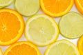 Lime fruit and orange slices making background Royalty Free Stock Photo