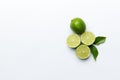 Lime fruits with green leaf and cut in half slice isolated on white background. Top view. Flat lay with copy space Royalty Free Stock Photo