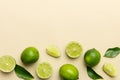 Lime fruits with green leaf and cut in half slice isolated on white background. Top view. Flat lay with copy space Royalty Free Stock Photo