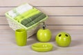 Lime green bath accessories with towels basket on wooden background