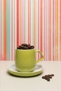 Lime green coffee cup and saucer filled with fresh coffee beans Royalty Free Stock Photo