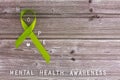 Lime green ribbon. Mental health awareness month concept mental health letters on old aged wooden background with Royalty Free Stock Photo