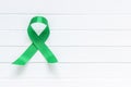 Lime Green Ribbon on white wooden background, world Mental health day.