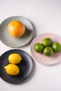 Lime, lemon, grapefruit in colorful plates on white background Royalty Free Stock Photo