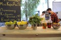 Lime, lemons, strawberries put at plates, basil and lemonade set at the counter cooks in the background