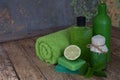 Lime mint composition of beauty threatment products in green colors on brown wooden background: shampoo, soap, bath salt, towel, o Royalty Free Stock Photo