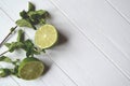 Lime and mint on the white wooden background.