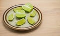 Lime sections with lime wedges on a small plate with copy space