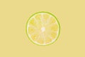 Lime slice on pastel yellow background