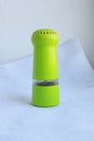 Limegreen peppermill. Kitchen equipment for grinding spices on a linen background. Front view