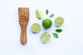 Limes with wooden lime squeezer on white