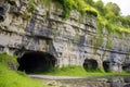 limestone cliff showing multiple cave entrances