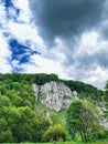 Limestone cliffs and green forest under dramatic storm clouds Royalty Free Stock Photo