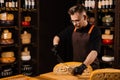 Limited maasdam cheese wheel cutting cheese in store. Cheese sommelier cuts yellow cheese wheel cut in half with a knife Royalty Free Stock Photo