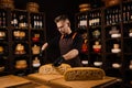 Limited maasdam cheese wheel cutting cheese in store. Cheese sommelier cuts yellow cheese wheel cut in half with a knife Royalty Free Stock Photo