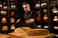 Limited maasdam cheese wheel cutting cheese in store. Cheese sommelier cuts yellow cheese wheel cut in half with a knife Royalty Free Stock Photo