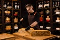 Limited maasdam cheese wheel cutting cheese in store. Cheese sommelier cuts yellow cheese wheel cut in half with a knife Royalty Free Stock Photo