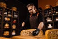 Limited maasdam cheese wheel cutting cheese in store. Cheese sommelier cuts yellow cheese wheel cut in half with a knife Royalty Free Stock Photo