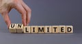 Limited or unlimited symbol. Businessman turns cubes, changes words `limited` to `unlimited`. Beautiful grey background, copy