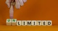 Limited or unlimited symbol. Businessman turns cubes, changes words `limited` to `unlimited`. Beautiful orange background, cop