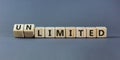 Limited or unlimited symbol. Turned wooden cubes and changed words `limited` to `unlimited`. Grey background, copy space. Busi