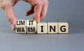 Limiting global warming symbol. Concept words Limiting and Warming on wooden cubes. Businessman hand. Beautiful grey table grey