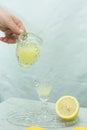 Female hand pouring a drink into a glass. Traditional homemade lemon liqueur limoncello and fresh citrus fruits on a Royalty Free Stock Photo