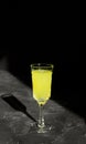 Limoncello liqueur or poncha drink with copy space on black surface in bright sunlight Royalty Free Stock Photo
