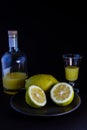 Limoncello traditional italian lemon liqueur with bottle, glass and fresh lemon halves Royalty Free Stock Photo