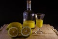 Limoncello traditional italian lemon liqueur with bottle, glass and fresh lemon halves Royalty Free Stock Photo