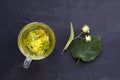 Linden flowers tea.Cup of hot herbal tea with linden fresh flowers on a black table Royalty Free Stock Photo