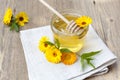 Linden honey in jar and calendula blossoms on wooden table Royalty Free Stock Photo