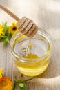 Linden honey in jar and calendula blossoms on wooden table Royalty Free Stock Photo