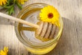 Linden honey in jar and calendula blossoms on wooden table Royalty Free Stock Photo