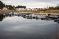 Small marina by a canal with white houses in the background..