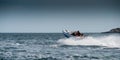 Blue and white powerboat cruising at high speed in a fjord.. Royalty Free Stock Photo