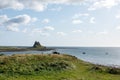 Holy Island Castle view from coastline with tide in blue sky