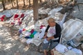 Lindos, Greece. 05/28/2018. Local woman from Lindos village is selling her handcrafted tablecloth, lying on ground to display