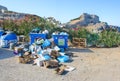 LINDOS ISLAND OF RHODES, GREECE Ã¢â¬â AUGUST 8 2019: Pile of rubbish down on ground near plastic litter bin on parking lot.