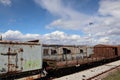 Line of abandoned rusty train wagons in a railway under a blue sky with clouds, Amyntaio, Greece Royalty Free Stock Photo