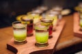 Line of alcohol green shots at wooden desk at bar counter Royalty Free Stock Photo