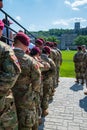 Line of army soldiers wearing their military camouflage uniform wait to march onto the parade field