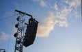 Line array speaker system hanging from pole during daylight performance