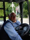 Line bus driver sitting in the driving seat with blue uniform on city bus