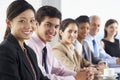 Line Of Business People Listening To Presentation Seated At Glass Boardroom Table Royalty Free Stock Photo