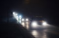 Line of cars in fog, with shining headlights in a foggy night Royalty Free Stock Photo