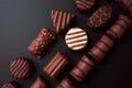 Line of chocolates of different shapes on a black background.