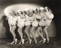 Line of chorus girls in white fur