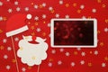 On line christmas holiday shopping concept. Santa claus red and beard hat next to tablet device Royalty Free Stock Photo