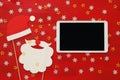 On line christmas holiday shopping concept. Santa claus red and beard hat next to tablet device Royalty Free Stock Photo